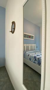 a mirror in front of a bedroom with a bed at Sunrise B&B Le castella in Le Castella