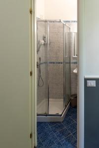y baño con ducha y azulejos azules. en San Pietro Roma Suite en Roma