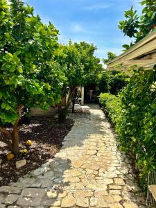 a garden with trees and a stone walkway at לארח, זה בטבע שלנו in Kfar Blum