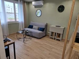 een woonkamer met een bank en een tafel bij T2 Cosy proche centre ville avec parking gratuit in Ajaccio