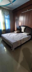 a bedroom with a large bed with a wooden wall at Radha Madhav in Vrindāvan