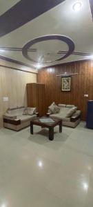 a room with two beds and a table in it at Radha Madhav in Vrindāvan