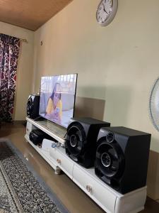 a living room with a tv and two speakers at Yogi Home Stay Near Freetown Airport in Freetown