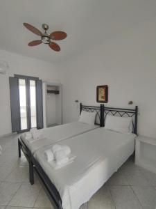 Schlafzimmer mit einem großen Bett und einem Deckenventilator in der Unterkunft The Anafians Studios in Anafi