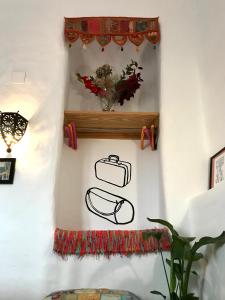 a wall with a shelf with a painting of a briefcase at Atelier 88 in Alcalá la Real