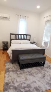 1 dormitorio con 1 cama grande y 1 alfombra en Gorgeous Victorian House!! Entire suite in SAM's home en Brooklyn