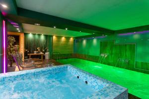 uma piscina com luzes verdes numa casa em Joan Apartments & Spa em Skopje