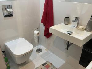 a white bathroom with a toilet and a sink at Słoneczny pokój z balkonem. in Gdańsk