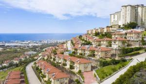 una fila de casas en una colina junto al océano en Alanya gold city hotel main building 3 bedroom apartment, en Alanya