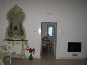 NovoliにあるB&B A casa delle zieの鏡と花のテーブルが置かれた部屋