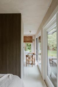 a bedroom with a large window and a table with chairs at Cabin Water Zuidermeer in Zuidermeer