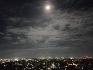 a view of a city at night with the moon at Staycation with overlooking view in Lo-oc