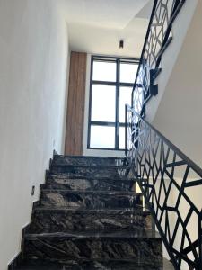 a staircase in a house with black stone stairs and a window at Miran San in Donji Štoj