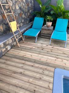 two chairs on a deck with a pool at La Casita Créole villa avec piscine et jacuzzi in Saint-Pierre