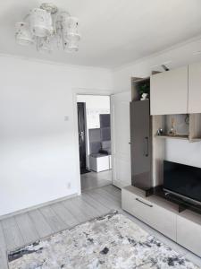 - une cuisine blanche avec des placards blancs et un tapis dans l'établissement Alexa Home, à Sânmartin