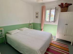 a bedroom with a white bed and a window at Anastasia, downtown village house in Amaliás