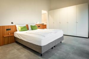 ein Schlafzimmer mit einem großen weißen Bett mit grünen Kissen in der Unterkunft B-Lodge Kärnten in Kirchbach
