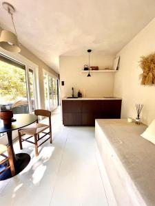 a kitchen and living room with a table and a couch at Cabin Water Zuidermeer in Zuidermeer