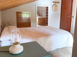 1 dormitorio con 1 cama y 1 mesa con lámpara en Casa Magnolia en Dosríus