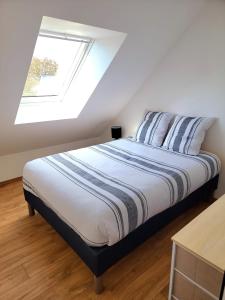 uma cama num quarto branco com uma janela em Appartement dans le bourg du Guildo - Saint-Cast em Saint-Cast-le-Guildo