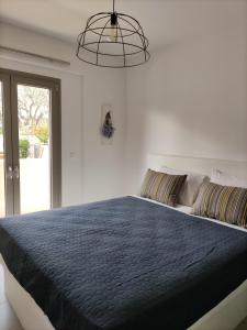 een slaapkamer met een groot bed en een blauw dekbed bij EmMi Houses in Ária