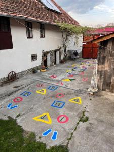 ein Hof mit gemalten Schildern auf dem Boden neben einem Haus in der Unterkunft Casa pe Valea Hartibaciului(Bărcuț) in Bărcuţ