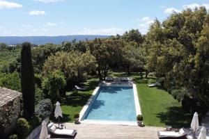 an outdoor swimming pool in a yard with trees at Villa Hautvallon in Gordes