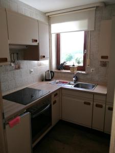 a small kitchen with a sink and a window at Pension Garni Talblick in Baiersbronn