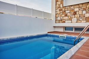 a swimming pool in a house with a stone wall at Petritis Villas B in Iraklitsa