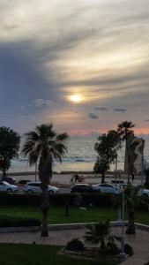 a park with palm trees and the ocean at sunset at First Sea Line Apartment, Acre - amazing coastal view in heart of Akko in Acre