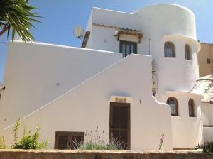 a white house with a spiral staircase at Casa Joana in Cala Santanyi