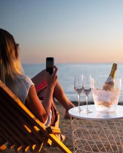 a woman taking a picture of a table with wine glasses at Apartments Lolo in Privlaka