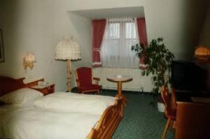 ヒルシャイトにあるブラウエライ ガストホフ クラウスのベッドルーム(ベッド1台、テーブル、テレビ付)