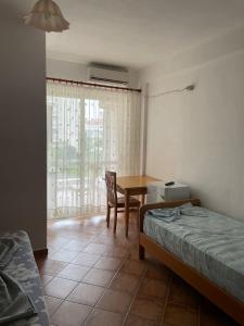 Vila Melisa في دوريس: غرفة نوم مع طاولة وسرير وطاولة وكراسي