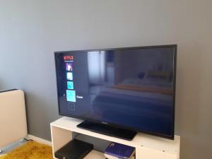 TV de pantalla plana grande en un soporte blanco en Studio in Eindhoven, en Eindhoven