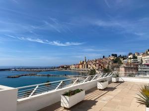 a balcony with a view of the water and buildings at Rêve de sable appartement avec jardin et parking in Menton