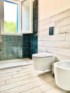 a bathroom with a toilet and a tub and a sink at Bilocale Punta Basano in Marettimo