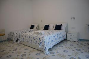 a bedroom with two beds and a white wall at Mary's Apartment in Maiori