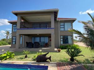 a house with a swimming pool in front of it at Villa Castellos in Inhambane