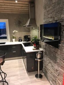 a kitchen with a stove and a stone wall at Topp moderne suite. in Larvik