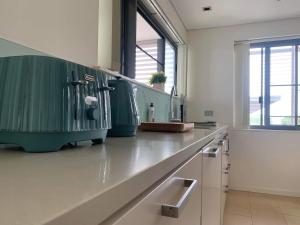 uma cozinha com um balcão com um lavatório em Darwin Waterfront Luxury Condo em Darwin