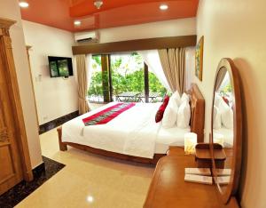 una camera da letto con un letto grande e una grande finestra di EL Rancho Beach Hotel a San Francisco Altre 61 foto