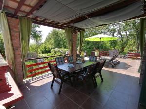 einen Tisch mit Stühlen und einem Sonnenschirm auf einer Terrasse in der Unterkunft The Forest House Krk 1 in Kras