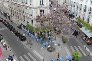 einen Blick über eine Stadtstraße mit einem Baum in der Unterkunft Hotel Royal Mansart in Paris
