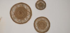 three wicker baskets sitting on a white wall at Mantalena's house in Antiparos +24 photos