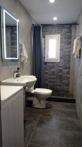 a bathroom with a sink and a toilet and a window at Mantalena's house in Antiparos