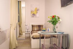 a room with a table and a chair with a vase of flowers at WATERFRONT SUITES CAGLIARI in Cagliari
