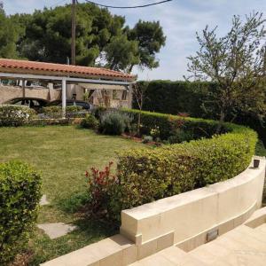 a garden with a retaining wall and a house at Takis house in Rafina