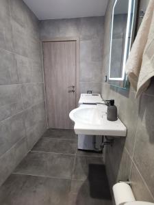 a bathroom with a white sink and a mirror at Mantalena's house in Antiparos