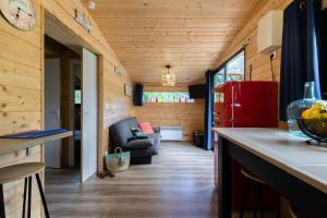 a kitchen and living room in a tiny house at Cabane ''Robinson'' dans les arbres de Nature et Océan à côté de la plage in Messanges